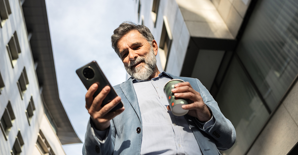 An older male agent on a smartphone