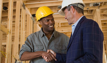 Two men shaking hands on construction site